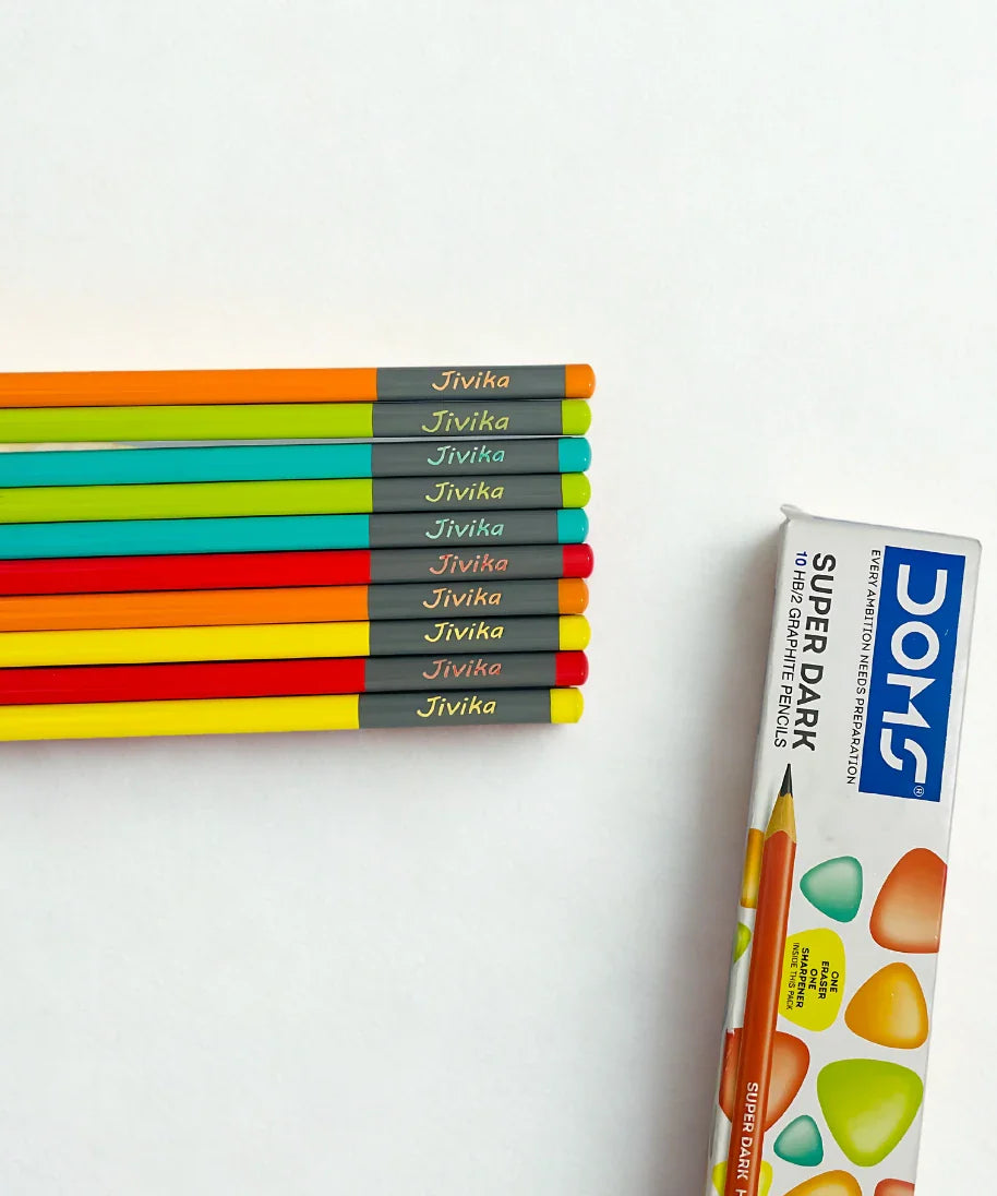 Set of 10 personalised Doms HB/2 name pencils in neon colors with custom child name printed, shown with original Doms Super Dark box