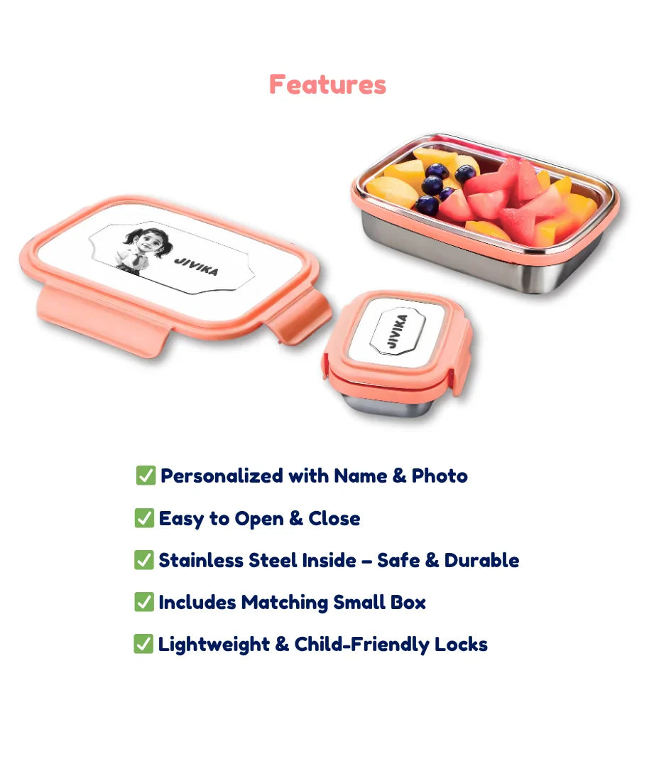 Personalised pink stainless steel lunch box for kids with custom name and photo printed on lid, matching small snack box and fruits inside.