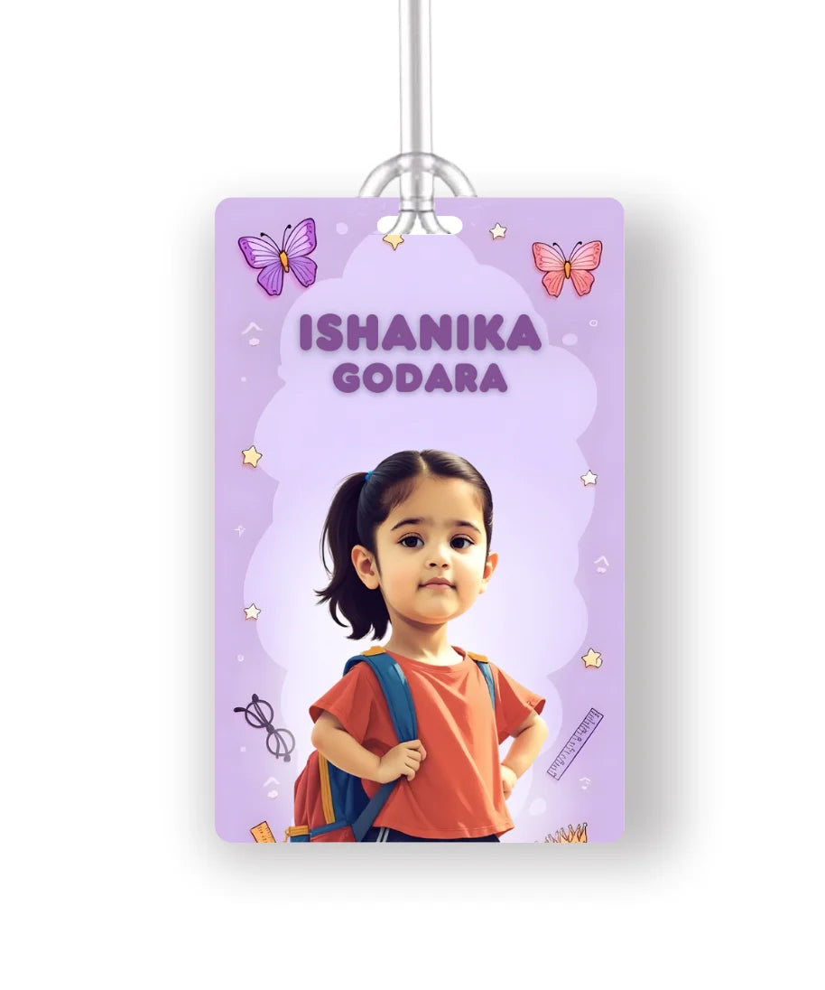 Personalised school bag tag with cartoon photo of a girl in red dress and name Ishanika Godara on purple butterfly background