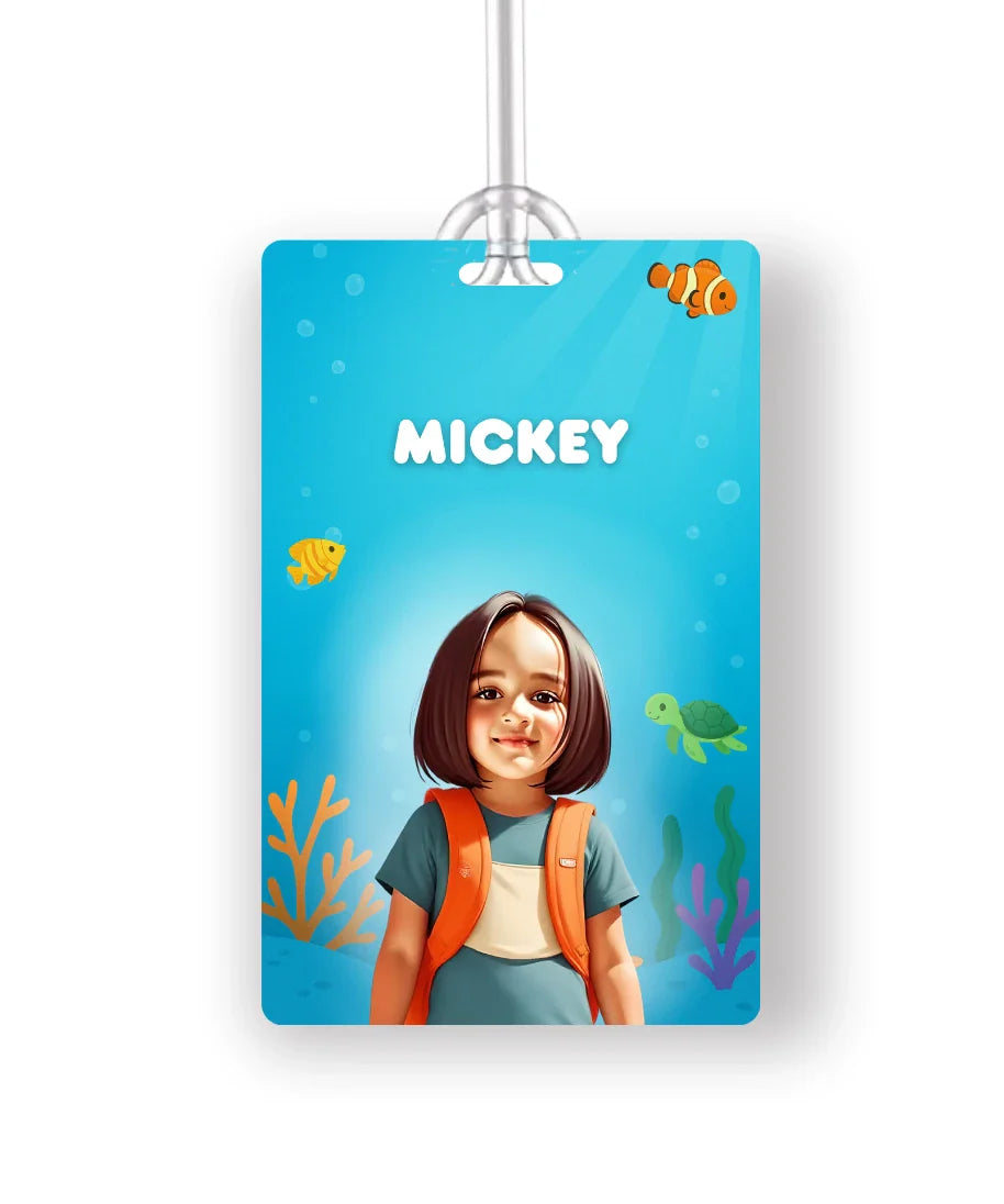 Personalised school bag tag with cartoon photo of girl in blue t-shirt and orange backpack on underwater ocean theme background